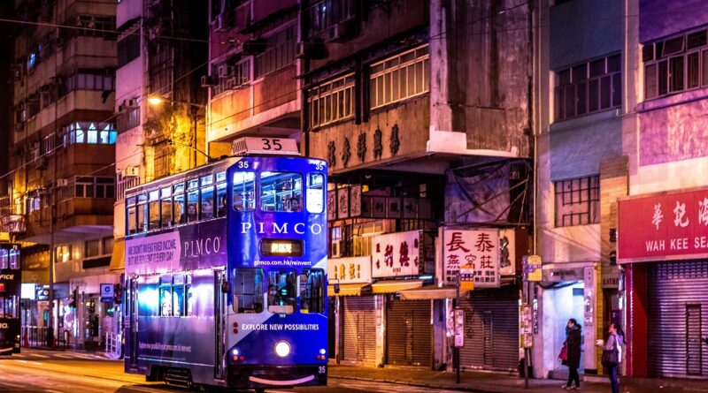 It's night time in Hong Kong. The run-down street looks cool in a urban-decayish kind of way. A blue double-decker tram sticks out in the foreground with a its splash of bright colour. On the front of it, it says "Explore New Possibilities" in white capital letters. Ain't that true.